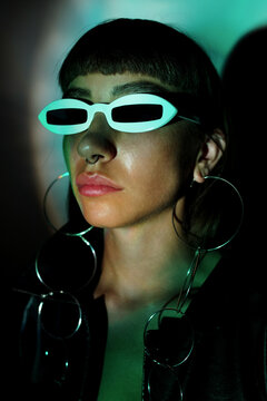 close-up of woman in black with big earings and white fashion sunglasses