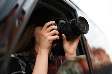 Private detective with camera spying from car - obrazy, fototapety, plakaty