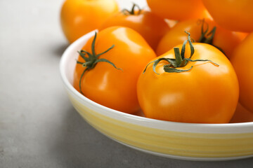 Ripe yellow tomatoes on grey table, closeup