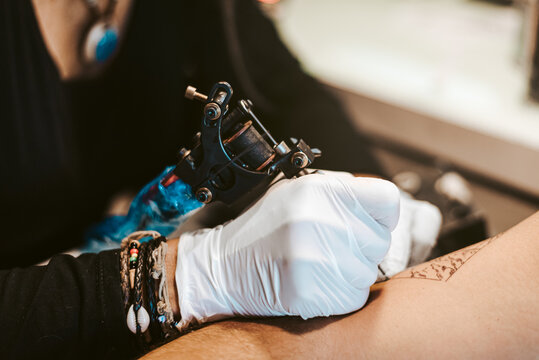 tattoo artist woman making tattoo for man