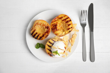 Delicious grilled peaches with ice cream served on white wooden table, flat lay