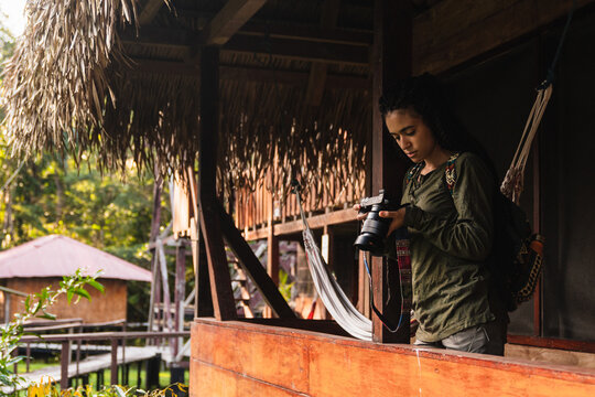Girl with a camera in her hand in a wooden cabin