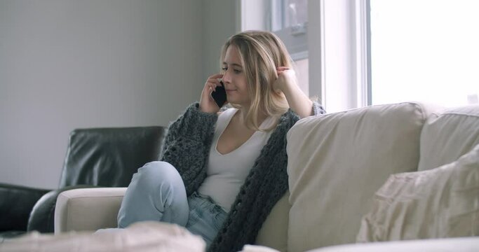 Woman Talking Calling on Cell Mobile Phone Smartphone gets Bad Sad Concerning Tragic News from Friend Family Doctor in Living Room on Couch