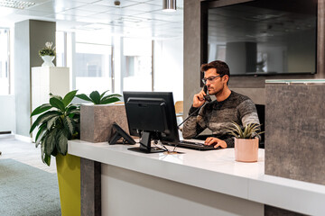 Busy employee calling on telephone at work space