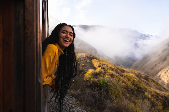 Girl with head out through the window of a train.