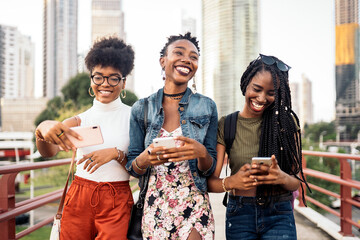 Three afro women using mobile phone