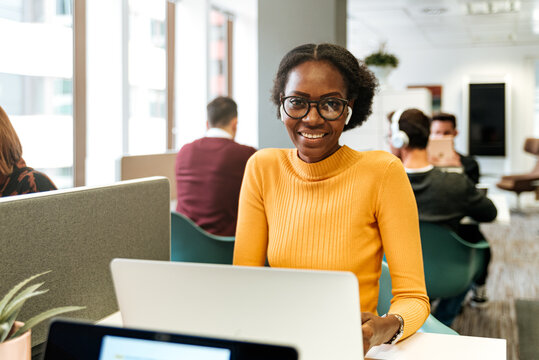 Content lady in earphones at desk in office space