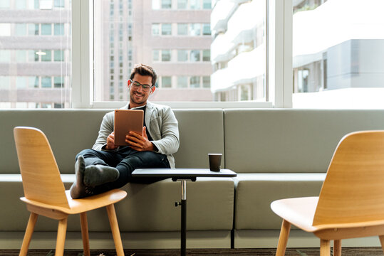 Cheerful freelancer using tablet at workplace