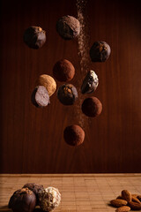 hand made chocolate truffles candies falling on wooden table