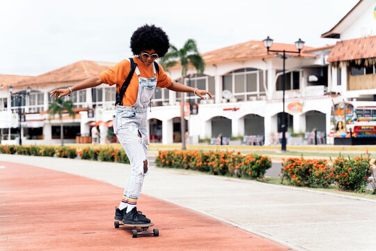 Afro woman riding skateboard