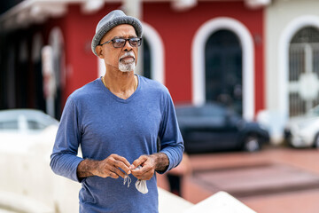 Senior black man standing in street.
