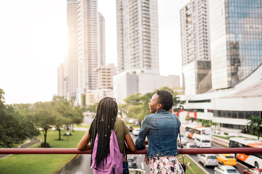 Rear view of two african girls together holding the railing