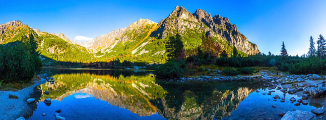 Picturesque panorama of mountain glacier lake Poprad (Slovak: Popradske pleso) in High Tatras (Slovak: Vysoke Tatry), Slovakia. Autumn in the mountains. Evening view - obrazy, fototapety, plakaty
