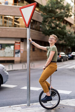 Young girl balancing on unicycle in the streets.