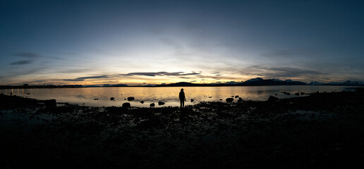 Panoramic photo of sunset over a lake.