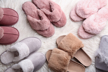 Fototapeta na wymiar Many different soft slippers on white faux fur, flat lay
