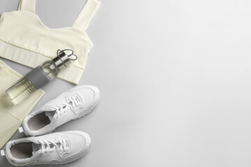 Flat lay composition with sportswear and equipment on light grey background, space for text. Gym workout