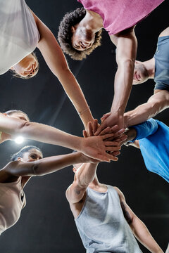 Group of people joining hands together.