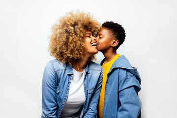 Black boy in studio kissing his mom.