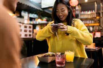 Chinese woman taking picture of her food.