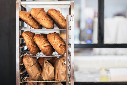 Loaves of bread lined up on metal shelves.