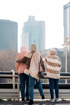 Three muslim women standing on the streets.