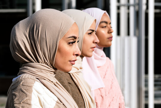 Three muslim women close from the side.
