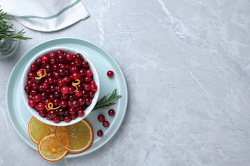 Flat lay composition with fresh ripe cranberries on grey table. Space for text