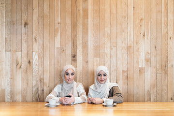 Two muslim women at cafe looking at camera