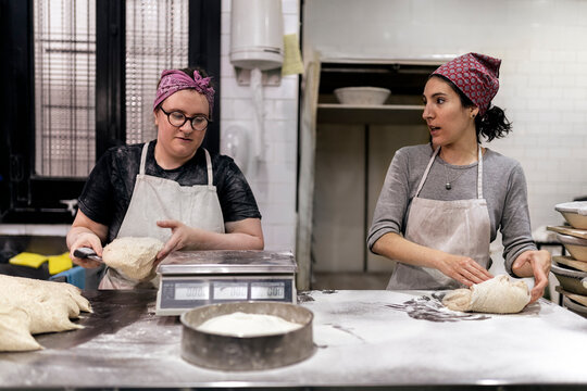 Women weighing dough in bakery.