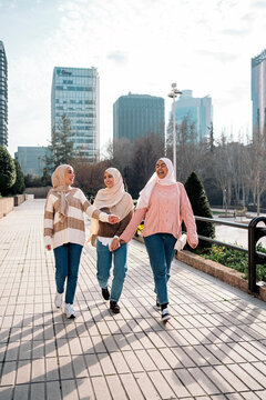 Three muslim women talking and laughing.