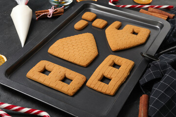 Parts of gingerbread house on black table, closeup