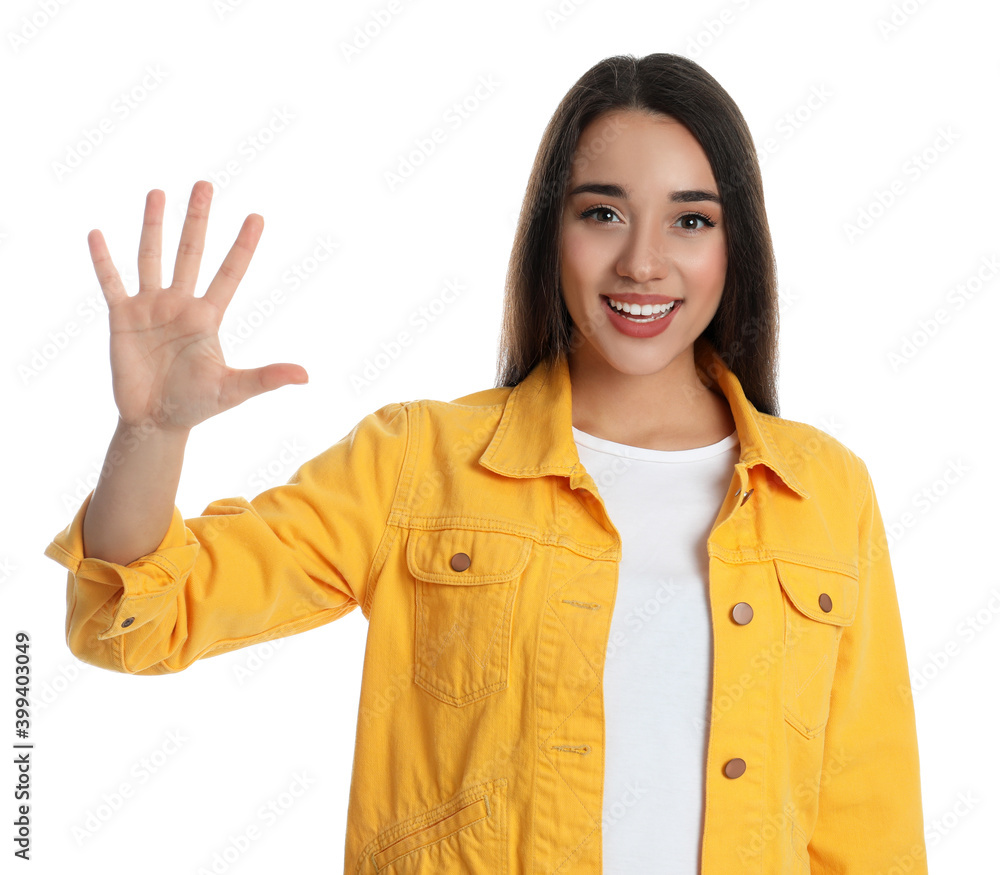 Wall mural Woman in yellow jacket showing number five with her hand on white background