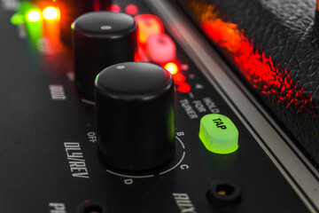 Detail of an amplifier for electric guitar with green and red lights