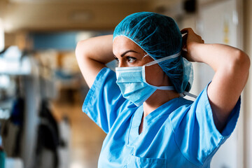 Unrecognizable doctor covering his face with mask