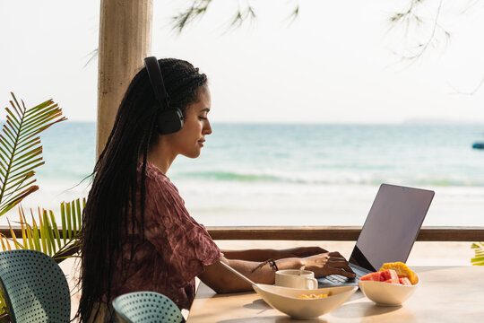 Black woman having breakfast on the beach - Powered by Adobe