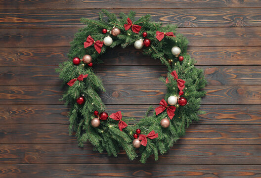 Beautiful Christmas wreath with festive decor on wooden background, top view