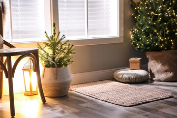 Small and big Christmas trees near window in room. Festive interior design