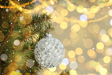 Beautiful bauble hanging on Christmas tree against blurred lights, closeup view with space for text. Bokeh effect