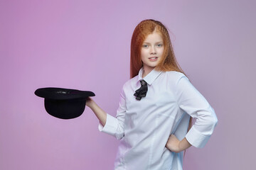 teenage girl with long red hair holds a hat in her hands