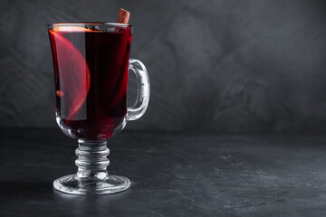 Aromatic mulled wine on black table, space for text