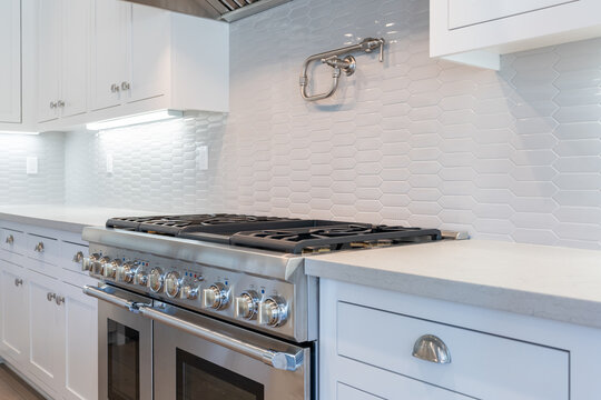 Modern Kitchen Details Of Granite Counter, Gas Stove, And Tile Backsplash. 