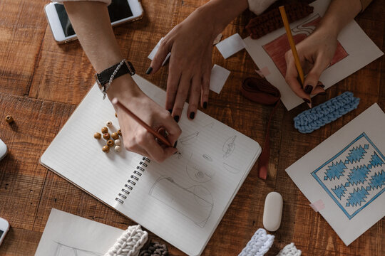 Cropped artists draw on paper