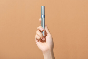 Mascara in hand isolated on a yellow