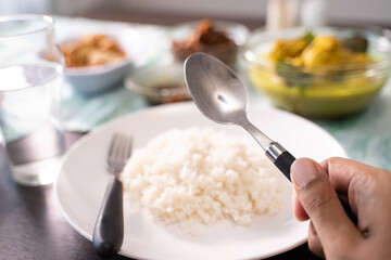 a plate of rice with many choice of indonesian side dishes for lunch or breakfast