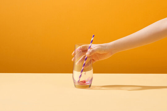 Hand taking a finished glass of beetroot juice.