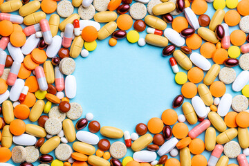 medicine pills, tablets, capsules frame over blue background. copy space. pharmacy industry concept