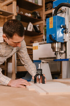 Joiner measuring depth of hole in wooden plank