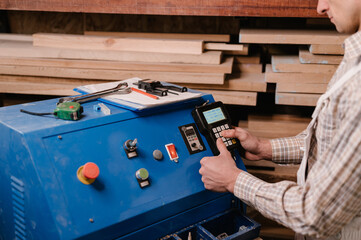 Crop carpenter pushing buttons on control panel