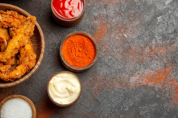 Crispy fried chicken with chopped tomatoes and spices on mixed color table